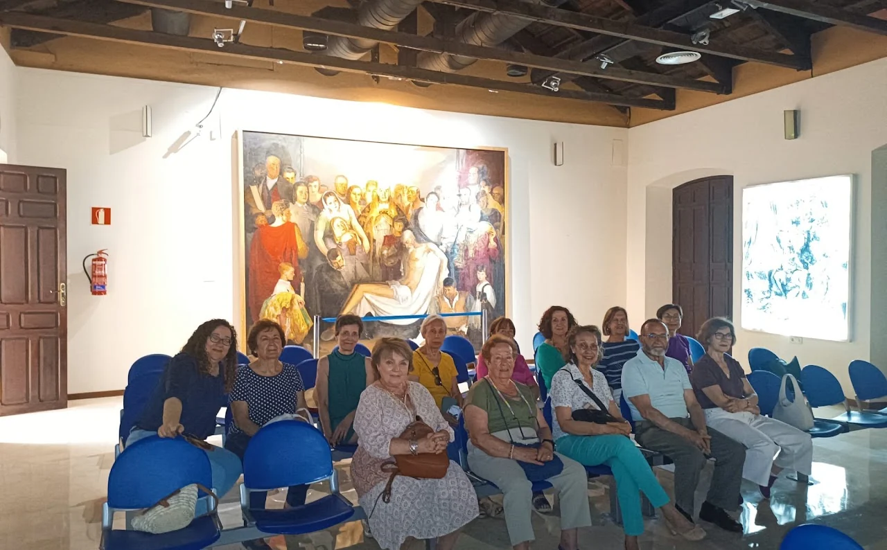 Alumnado del CEPA durante una clase en el salón de actos del Museo del Quijote ante el cuadro El entierro de Don Quijote.